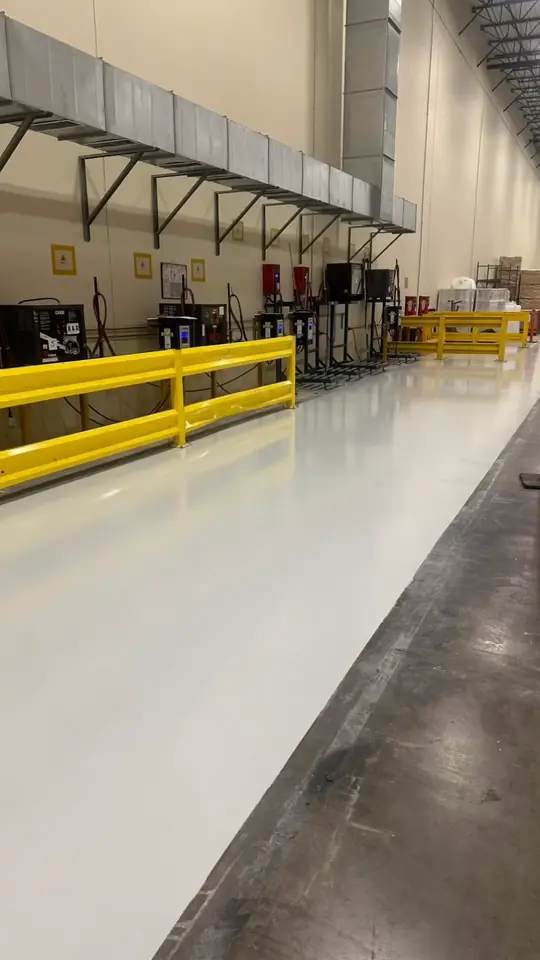 Before and after of a commercial warehouse floor coating in Arlington, TX, with forklift aisles and safety rails.